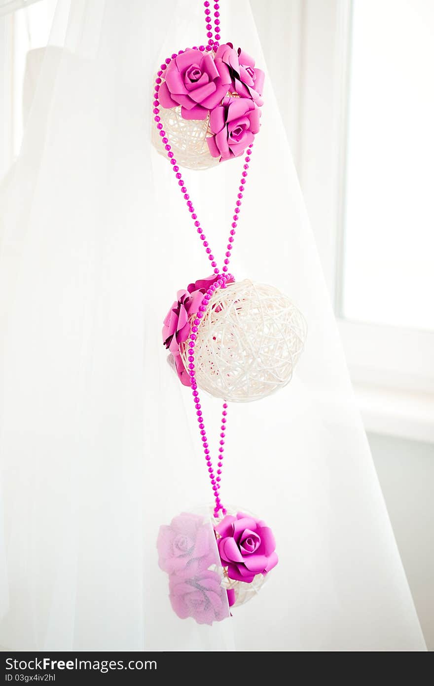 Bridal decorations of white spheres of bars with pink paper flowers and pink beads. Bridal decorations of white spheres of bars with pink paper flowers and pink beads