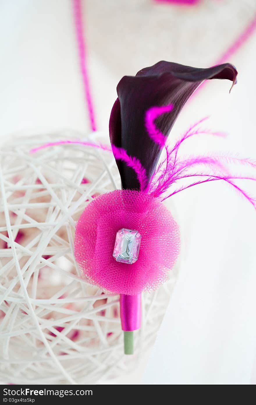 Bridal decoration of white sphere of bars with groom's pink boutonniere of black calla