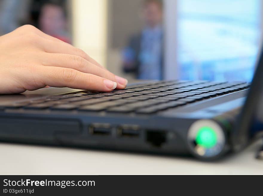 Woman's hand on the laptop keyboard.