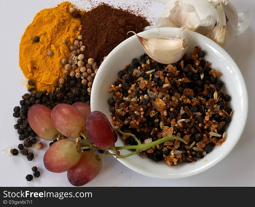 Selection of spices, garlic and grapes top view onto a table. Selection of spices, garlic and grapes top view onto a table