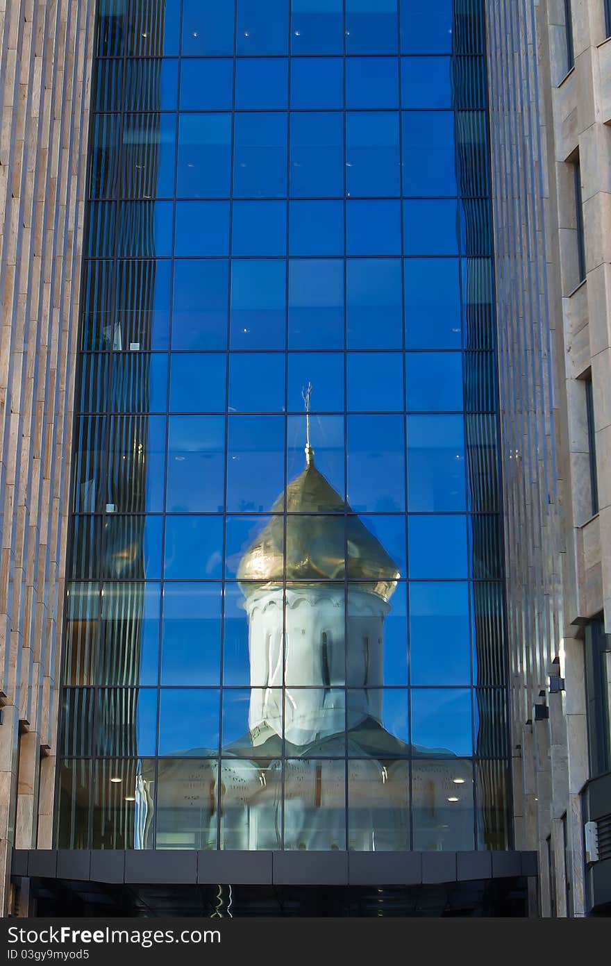 Old orthodox church reflected in a glass wall of new office building in the downtown of Moscow. Old orthodox church reflected in a glass wall of new office building in the downtown of Moscow