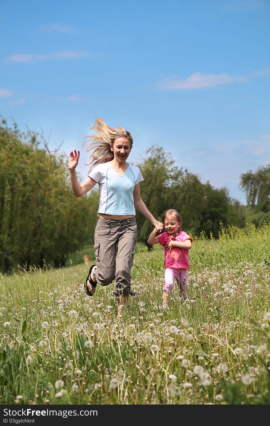 Mother and daughter walking on path holding hands