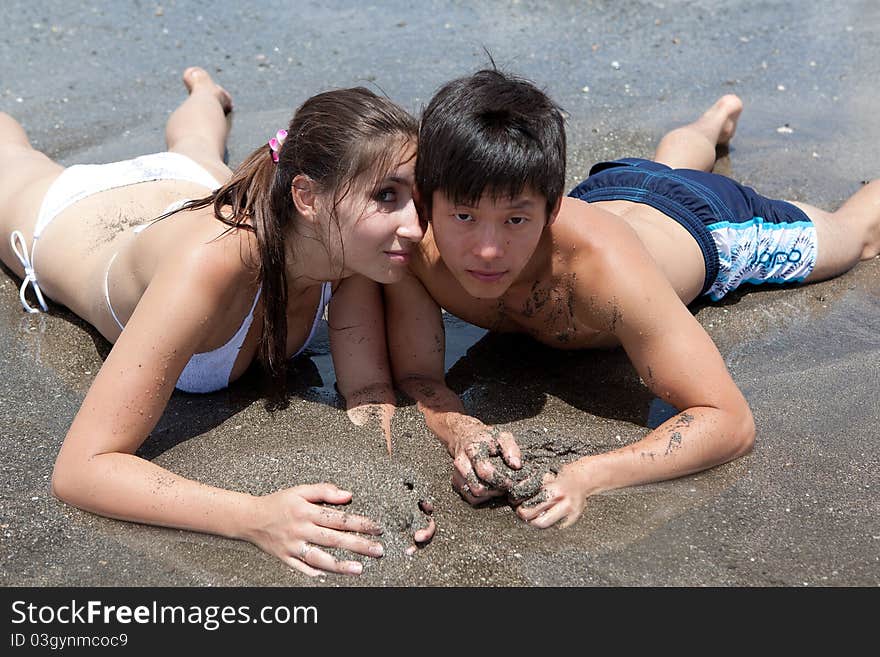 Young girl and asian boy on the ocean's beach. Young girl and asian boy on the ocean's beach