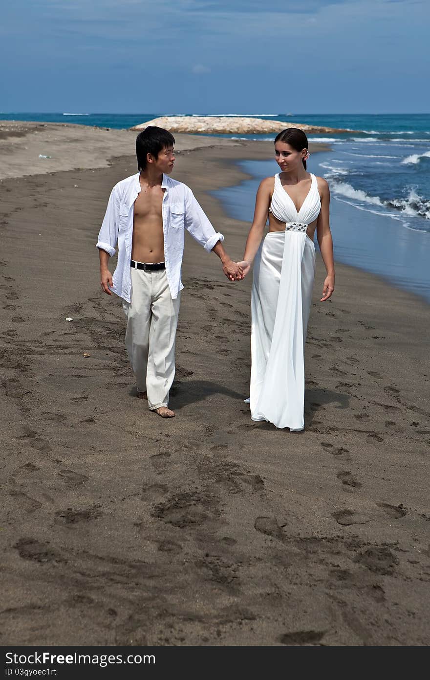 A young couple walk on a beach