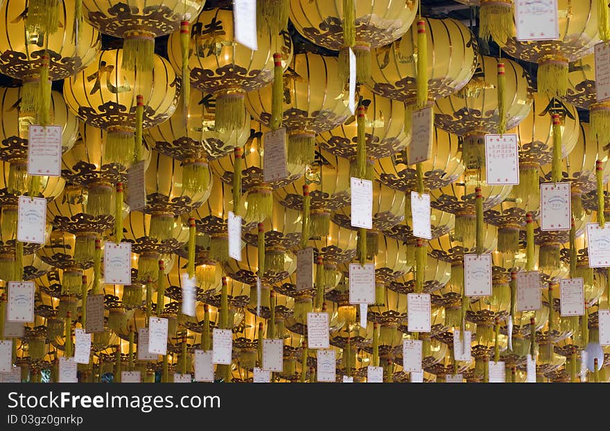 Rows of yellow chinese lanterns hanging from ceiling