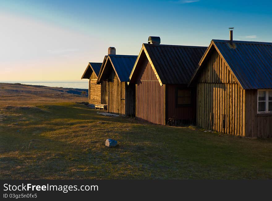 Four houses on the coast at twilight. Four houses on the coast at twilight