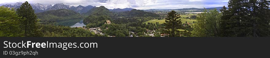 Panoramic view of Hohenschwangau Castle in the valley net to the lake and high peaks at the back in Germany