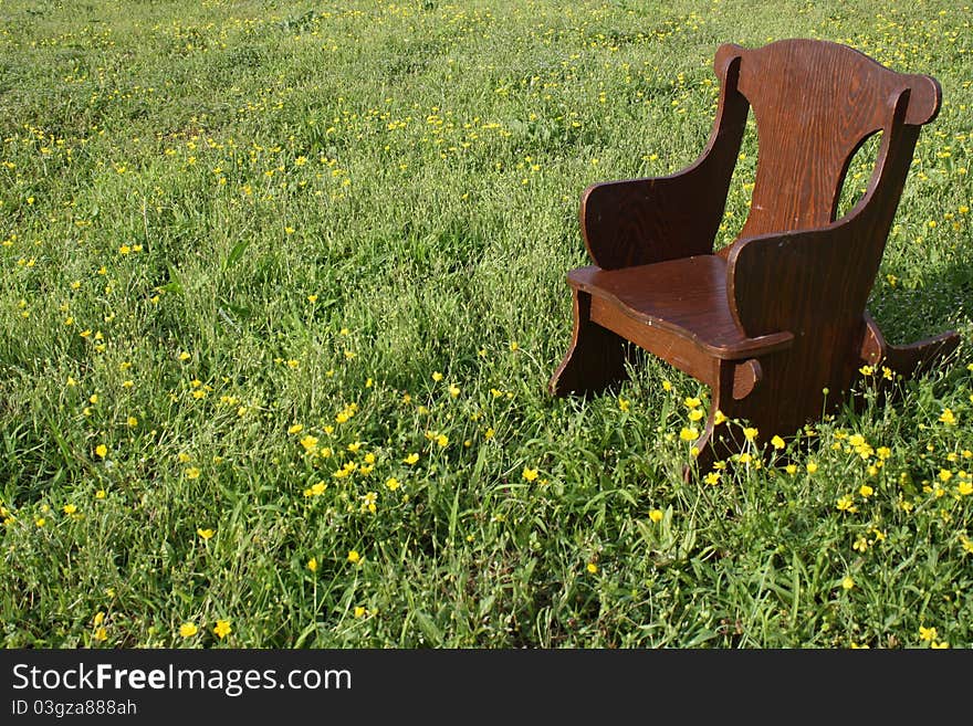 Brown children's rocking chair in peaceful meadow. Brown children's rocking chair in peaceful meadow.