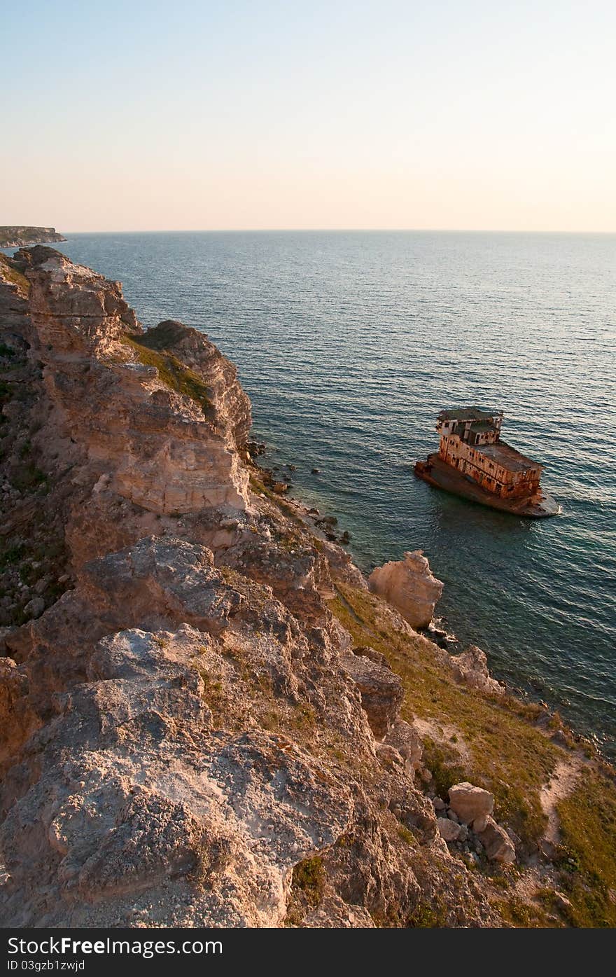 Sunken ship near the rocky shore