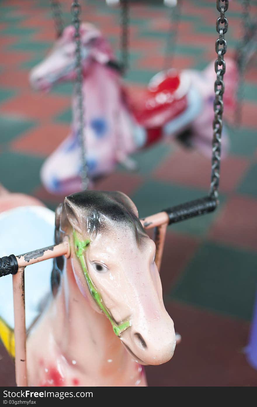 Pnk pony in a carousel in children's playground. Pnk pony in a carousel in children's playground