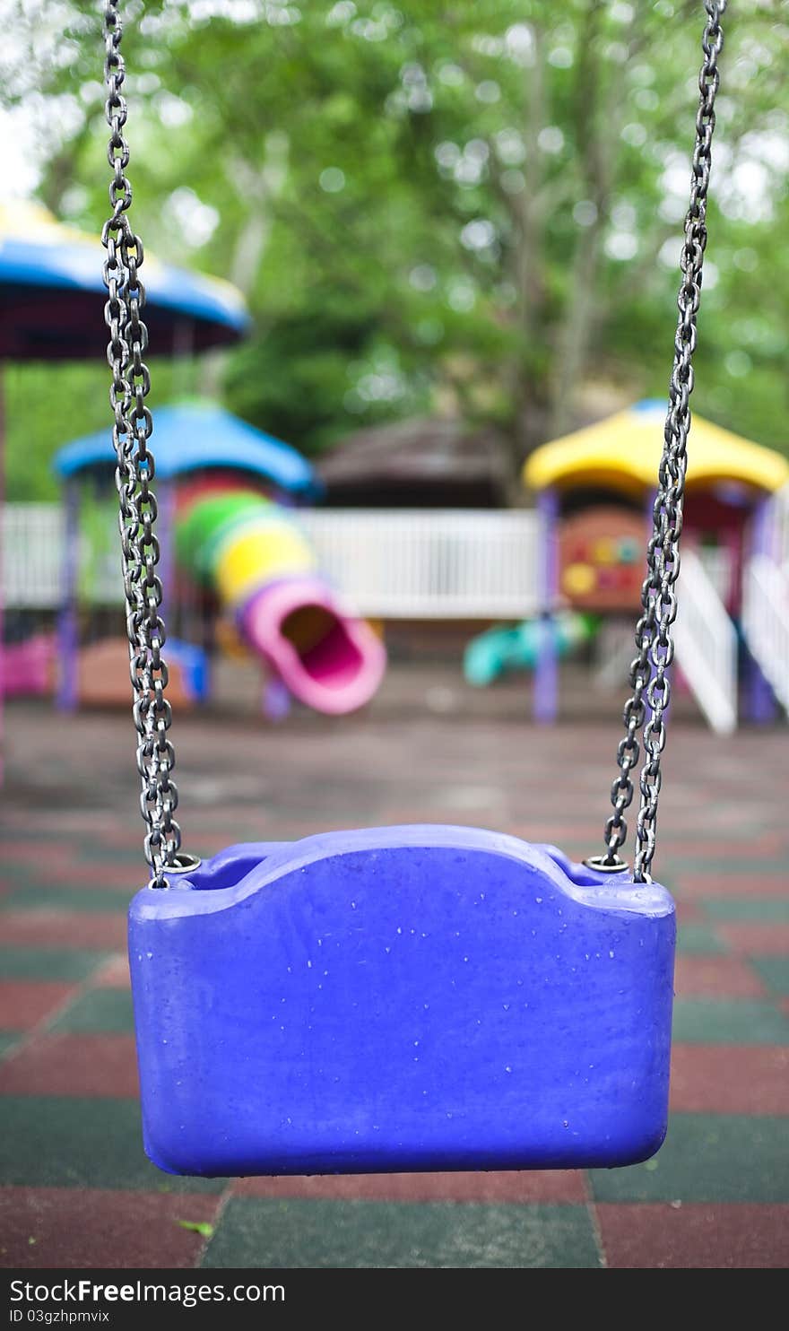 Back view of a blue child's swing in a playground. Back view of a blue child's swing in a playground