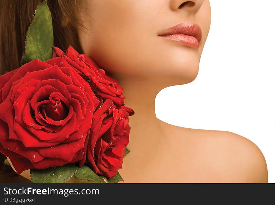 A studio view of the bare shoulder of a woman with three lightly colored roses. A studio view of the bare shoulder of a woman with three lightly colored roses