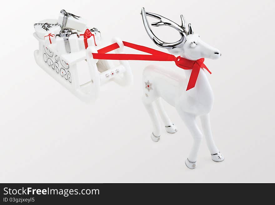 Figurine of reindeer pulling Santa's sleigh full of presents, against white background. Figurine of reindeer pulling Santa's sleigh full of presents, against white background