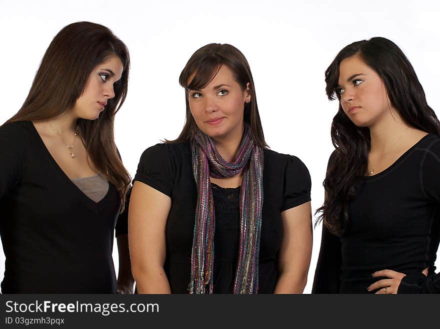 Two young sisters looking in dis-approval at their other sister. Two young sisters looking in dis-approval at their other sister