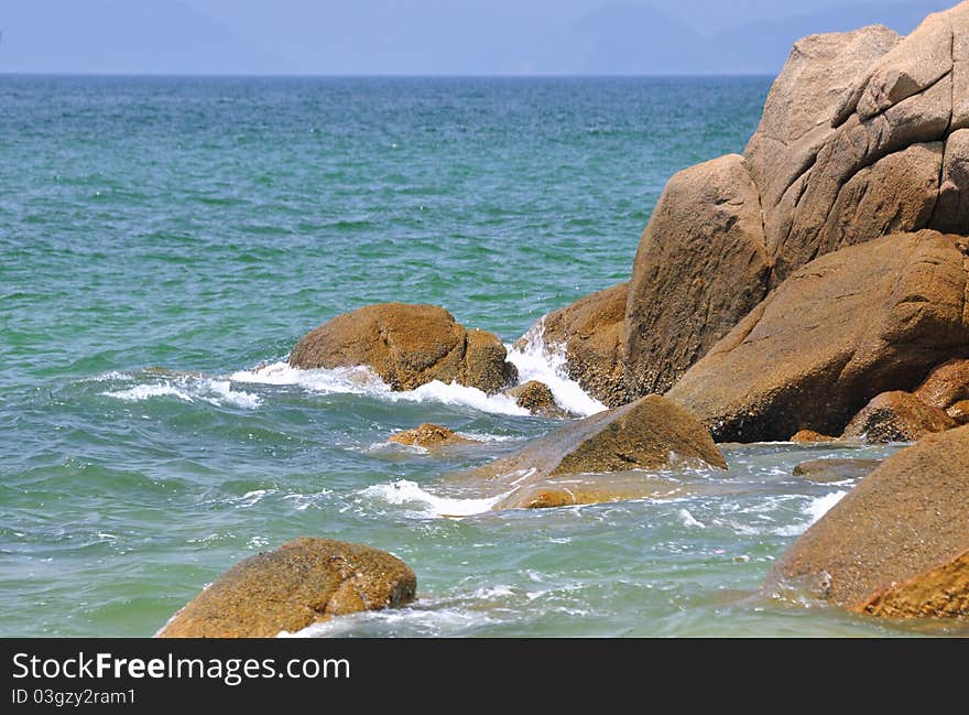 Deep ocherous rock in the sea beach,  shown as color and shape comparing between water and rock. Deep ocherous rock in the sea beach,  shown as color and shape comparing between water and rock.