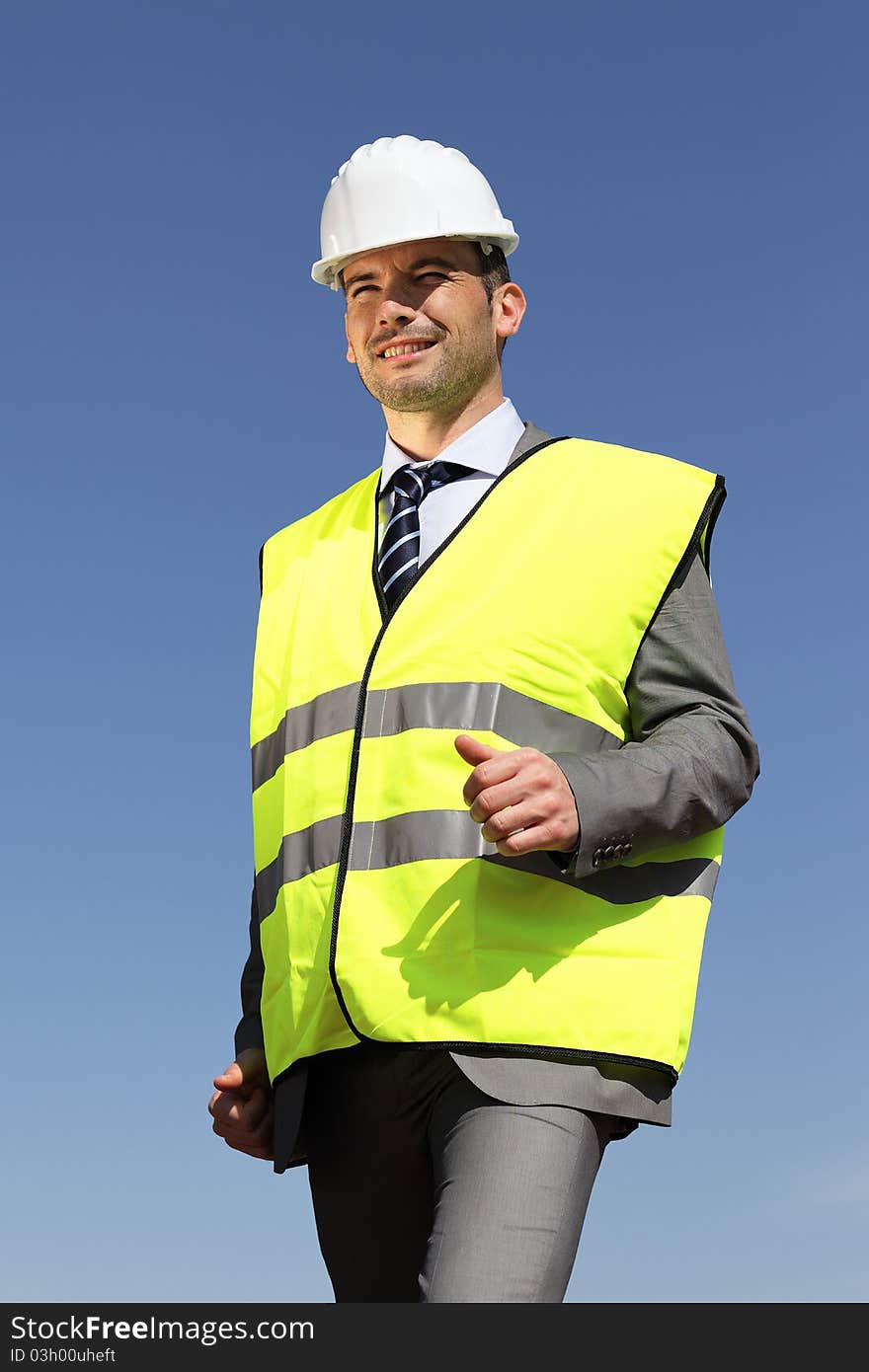 Young businessman with hardhat and blue sky