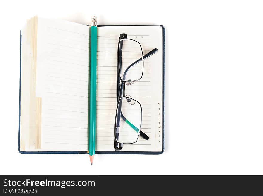 Notebook and eyeglasses isolated on a white background