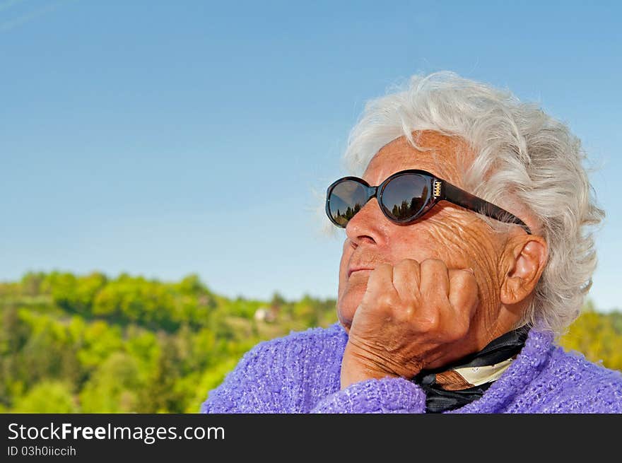 Senior woman is dreaming, picture taken during the sunny day.