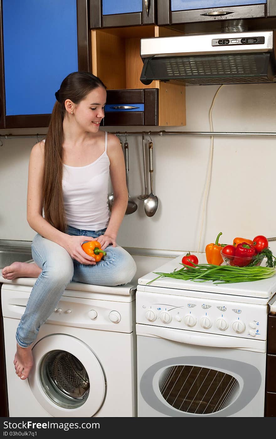 Young beautiful caucasian woman in the kitchen with vegetable