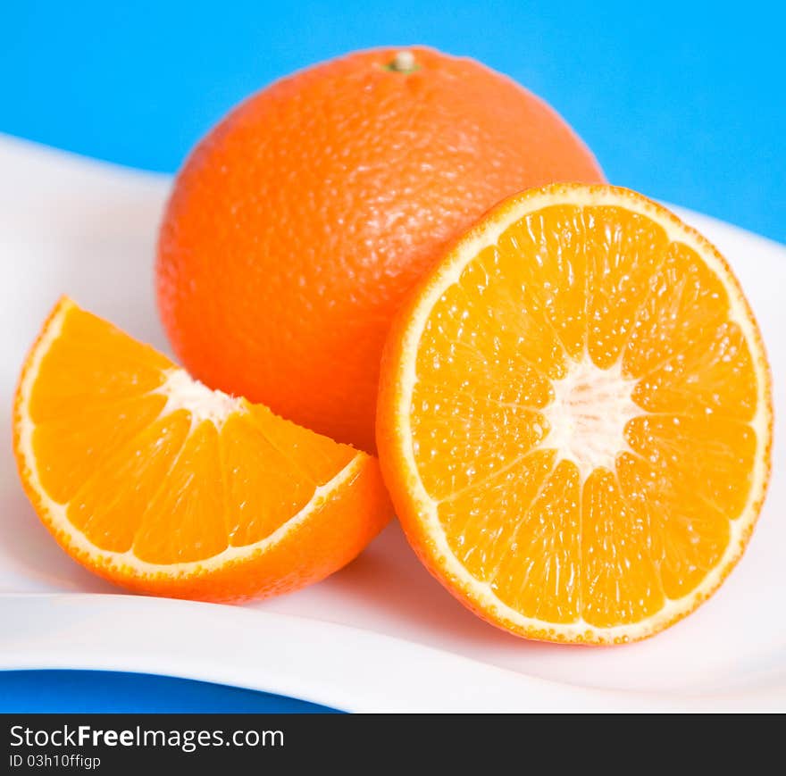 Fresh oranges on a white plate