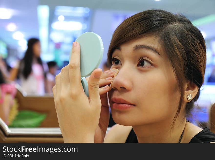 Young asian lady applying make up. Young asian lady applying make up