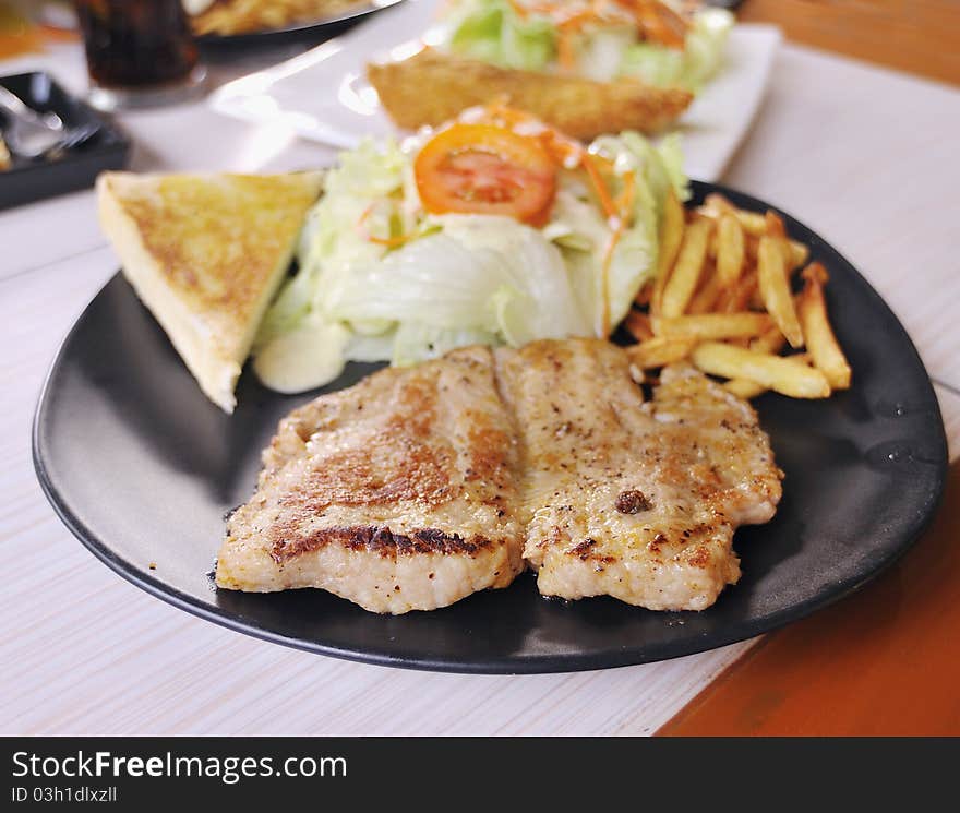 Fried pork steak with onion on the plate,shallow focus