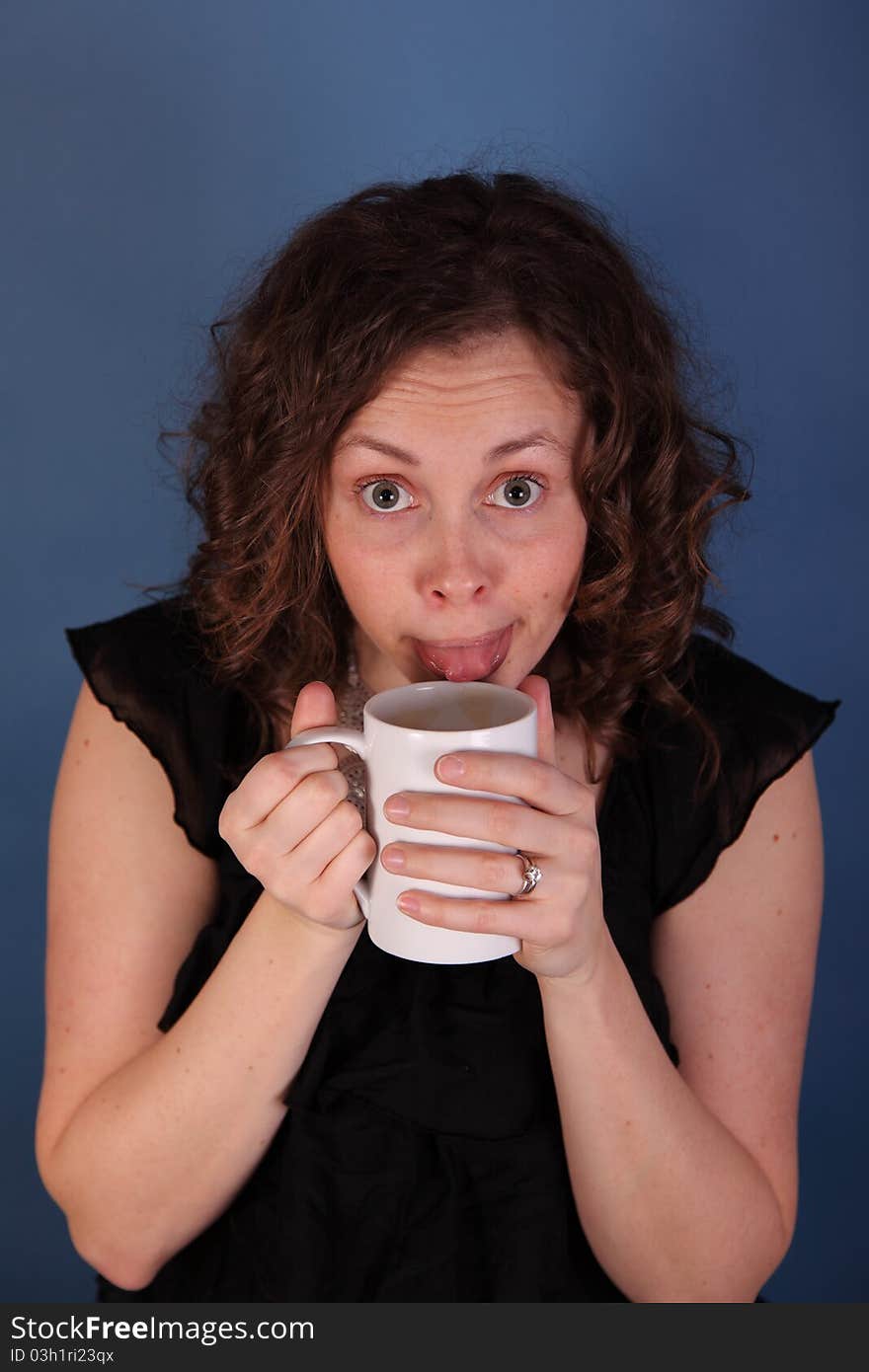 Young woman tests coffee with tongue. Young woman tests coffee with tongue.