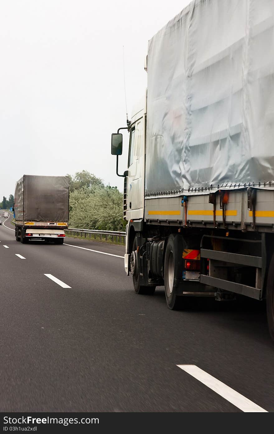 Trucks traveling on highway delivering goods. Trucks traveling on highway delivering goods