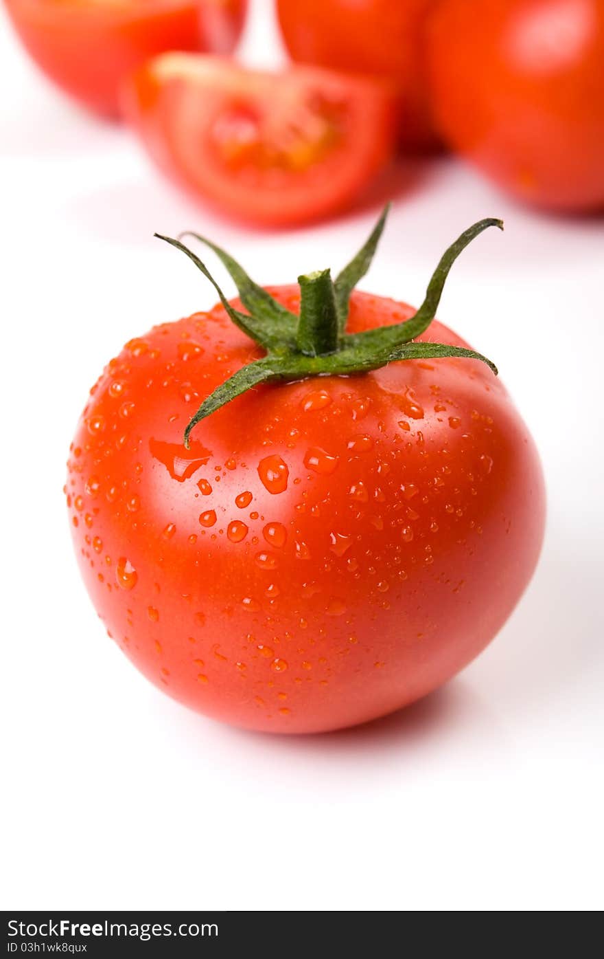 Tomato with water drops close-up on the white.