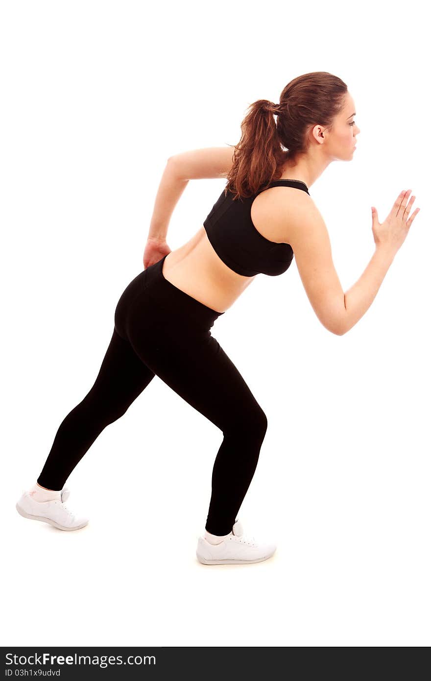 A young female dressed in gym clothes in a dynamic running position on isolated white background. A young female dressed in gym clothes in a dynamic running position on isolated white background