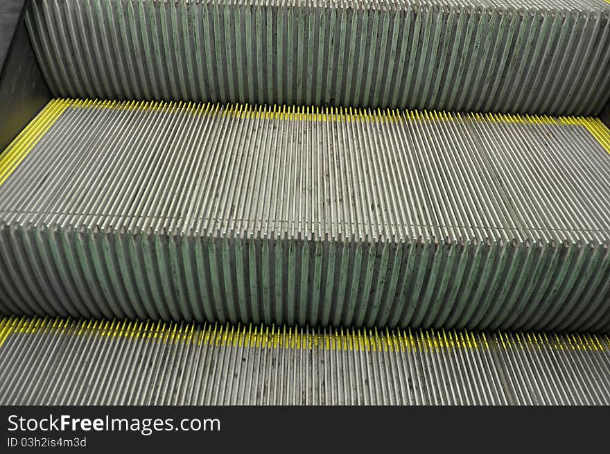 Steps on a escalator with yellow markings on the edges. Steps on a escalator with yellow markings on the edges