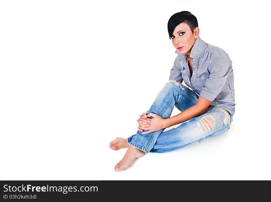 Beautiful short haired young Caucasian woman in blue jeans, over white background