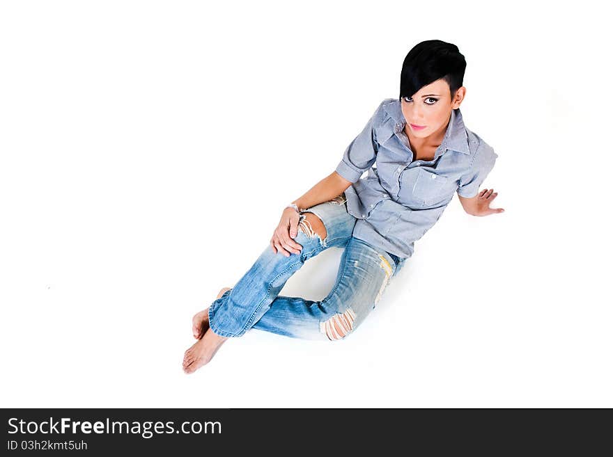 Beautiful short haired young Caucasian woman in blue jeans, over white background