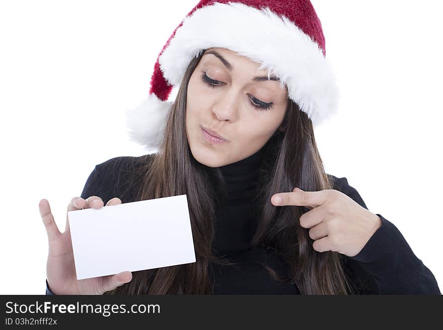 A beautiful woman wearing christmas hat and pointing to an empty card. A beautiful woman wearing christmas hat and pointing to an empty card