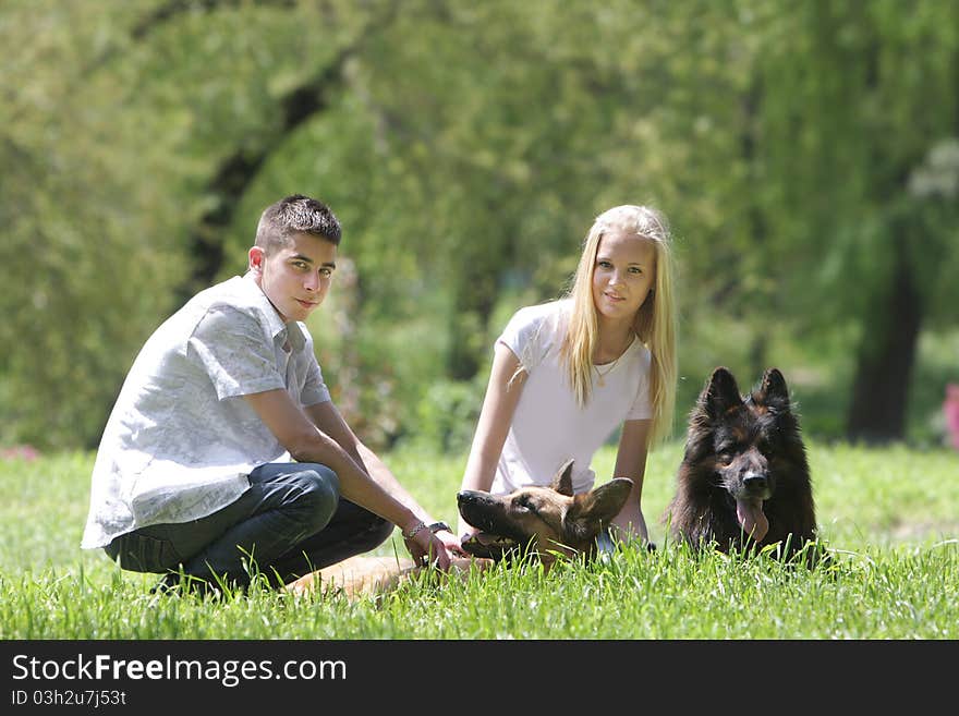 Young couple with two dogs on natural background