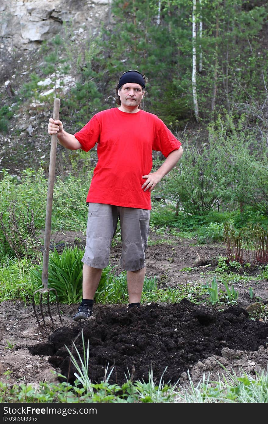 The image of peasant stands with a pitchfork