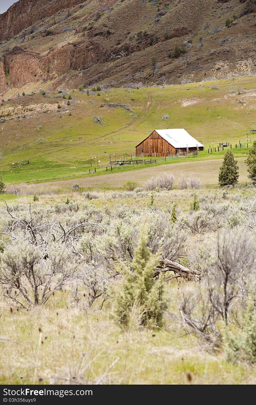 An old barn sits on the side of a hill overlooking the meadow below in central Oregon. An old barn sits on the side of a hill overlooking the meadow below in central Oregon.