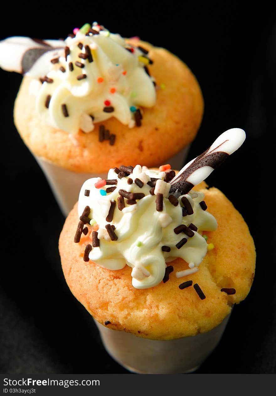 Butter muffins topping with mousse an chocolates ships isolated