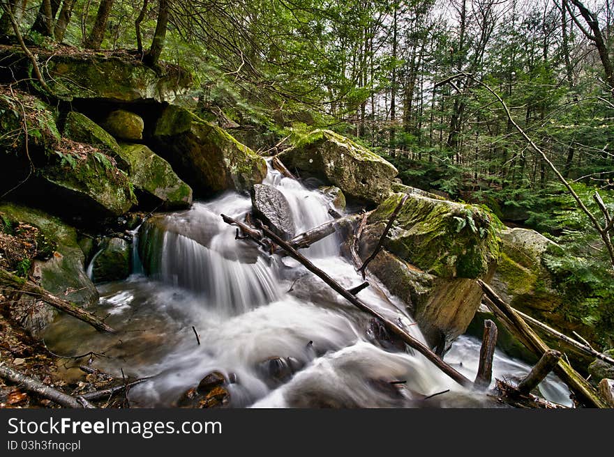 A forest stream in Pennsylvania streams down through the rocks and deadfalls. A forest stream in Pennsylvania streams down through the rocks and deadfalls.