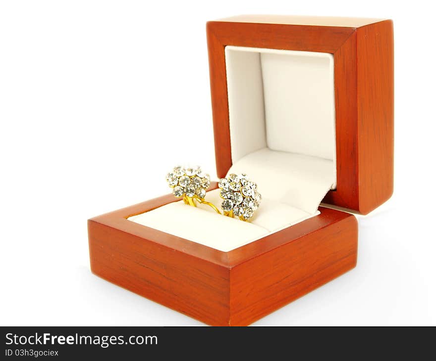 Diamond earrings and yellow gold, isolated towards white background, in a wooden gift box towards white background