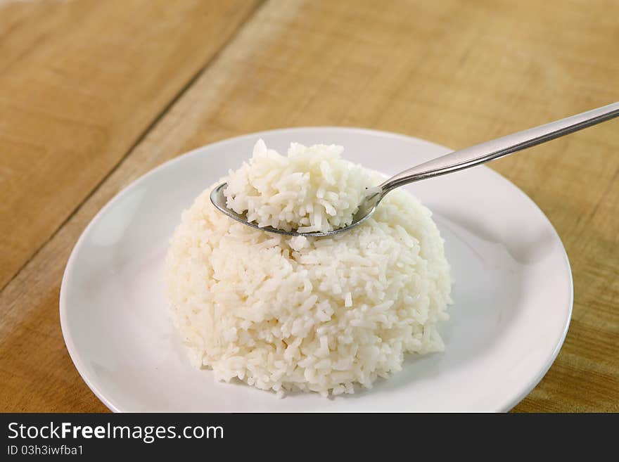 Rice in spoon  on table