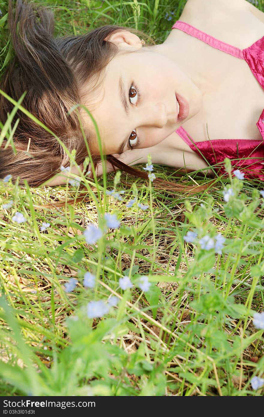 The portrait of beautiful young lady on the grass