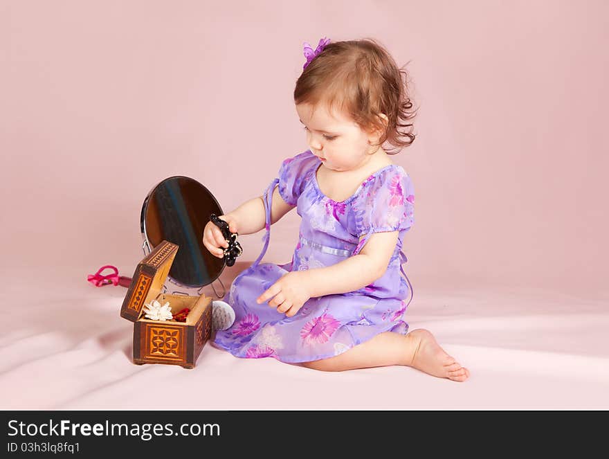 Cute little girl playing with her toys in the studio