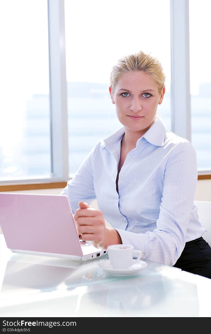 One happy young business woman working on laptop computer at group team meeting at modern office. One happy young business woman working on laptop computer at group team meeting at modern office