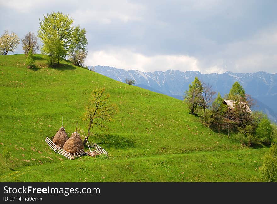 House And Haystacks On Beautiful Hills