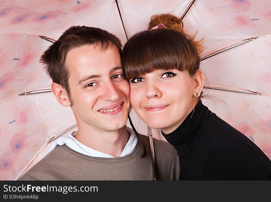 Couple under a pink umbrella. Couple under a pink umbrella