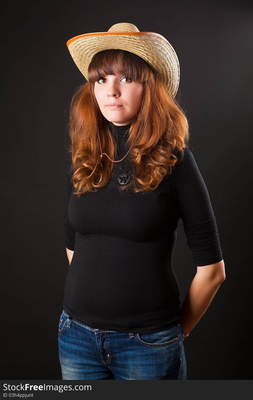 Beautiful girl in a cowboy hat on black background. Beautiful girl in a cowboy hat on black background