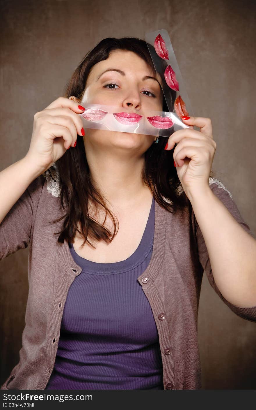 Funny young brunette woman with lipstick palette