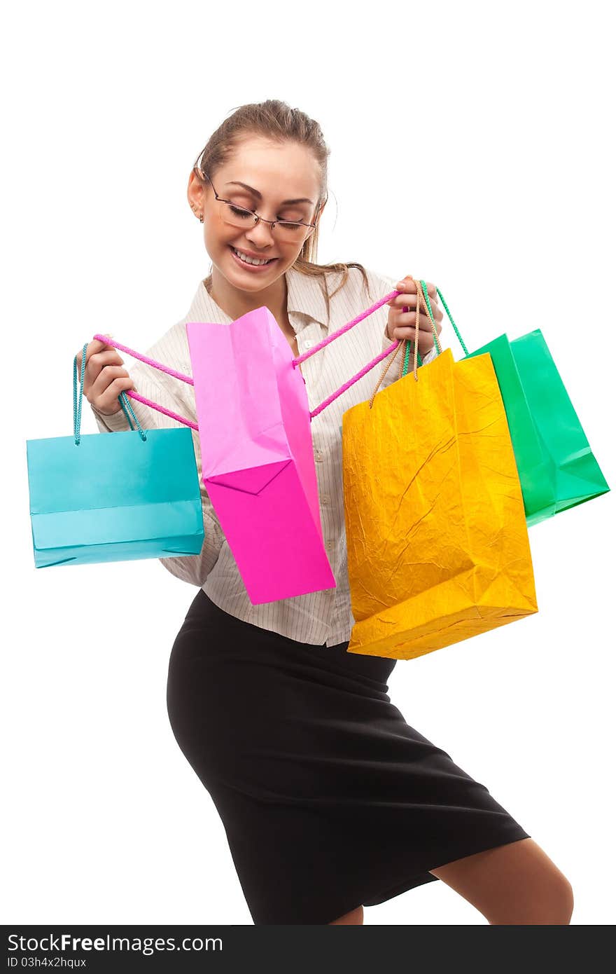 Businesswoman peeping in shopping bags over white. Businesswoman peeping in shopping bags over white