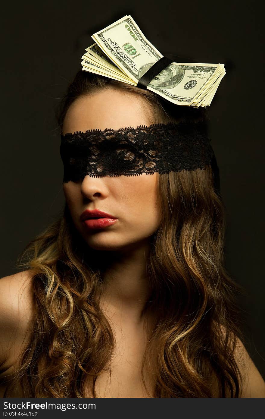 Beautiful woman head-dressed with dollars looking through black openwork lace in darkness. Beautiful woman head-dressed with dollars looking through black openwork lace in darkness